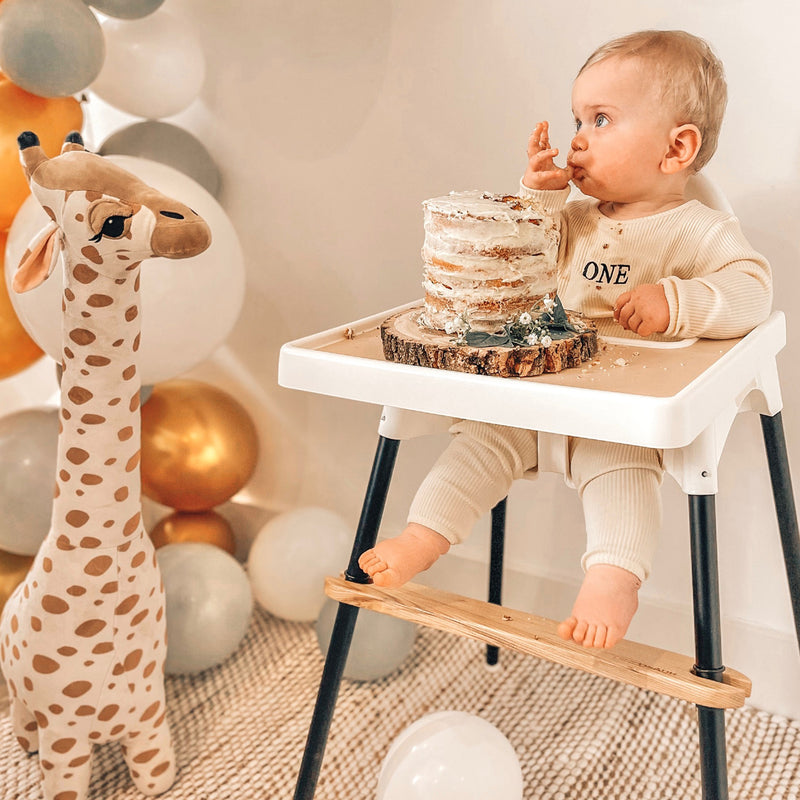 baby celebrating first birthday smash cake in boho ikea highchair glow up, cream placemat and ash foot rest uk and black legs